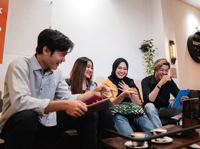 Group of Smiling Teenagers Staying Together Using Gadget